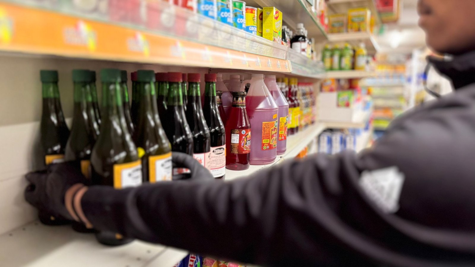 An assitant packing a neat and well designed store shelf